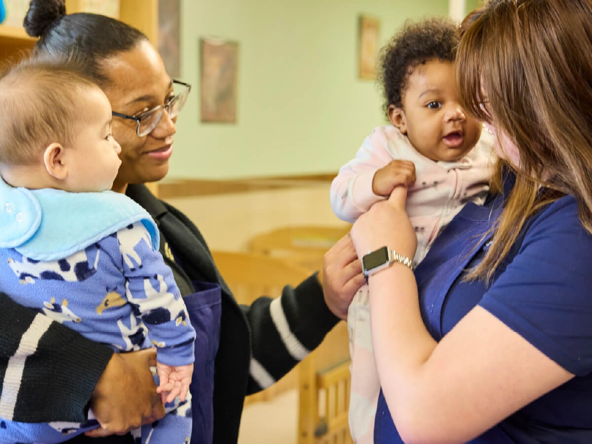 Teacher and parent holding infants